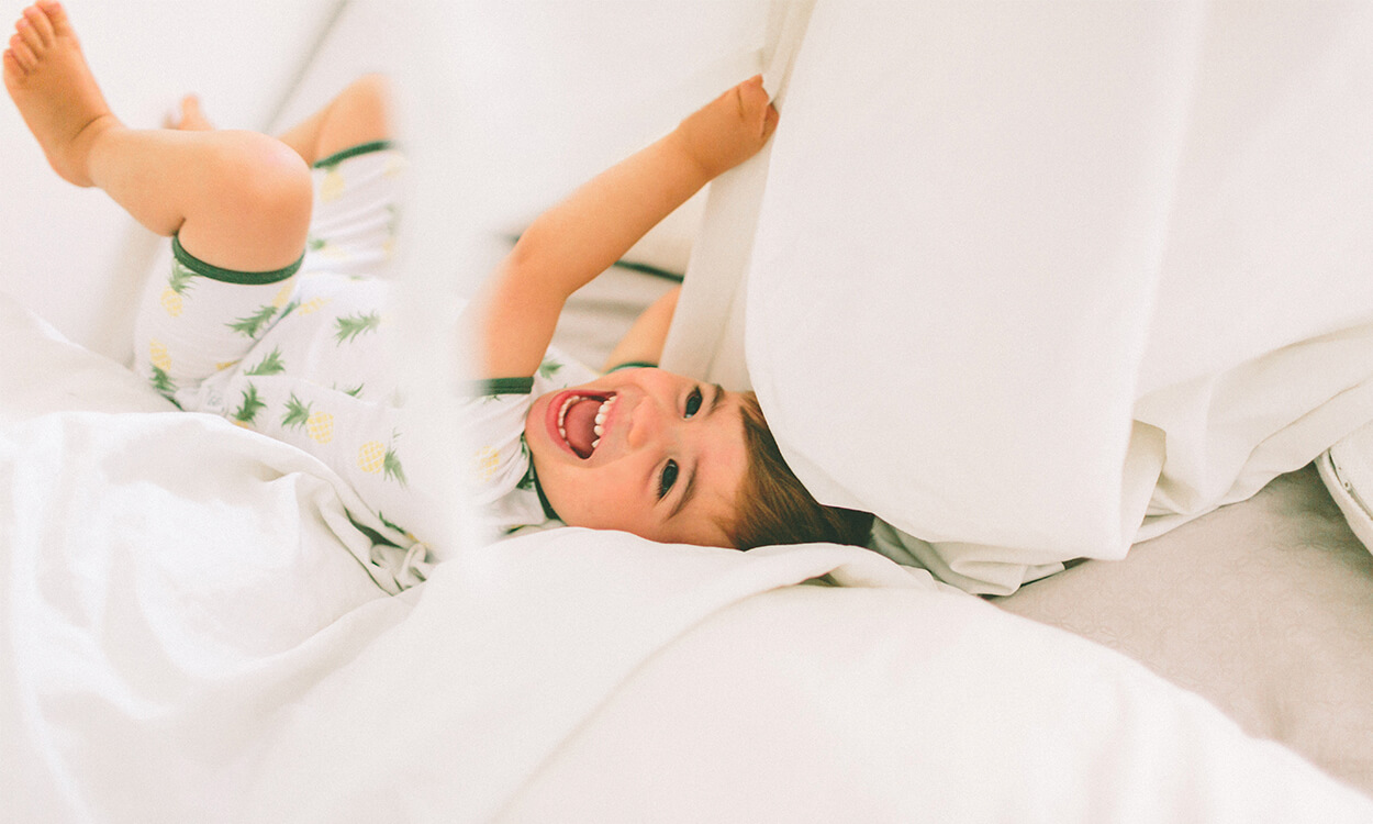 Baby playing in clean sheets